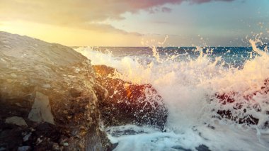 Ufuk ve günbatımı üzerinde köpük denize Ccoastal taşlar ve dönüş ara dalgalar