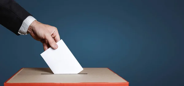 Seçmen tutan el mavi arka plan oy pusulasında yukarıda zarfta. Özgürlük demokrasi kavramı