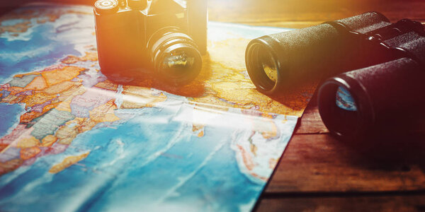 Adventure Travel Scout Journey Concept. Black Film Camera, Map And Binoculars On Wooden Table, Panoramic View.