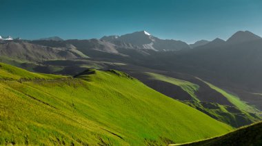 Dağ manzara şafakta. Yeşil alan ve mavi gökyüzü. Turizm Seyahat kavramı