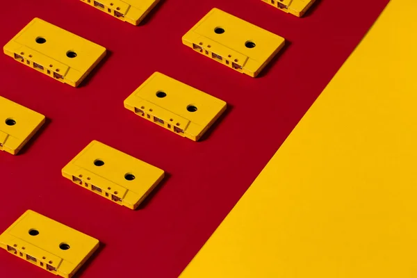 Yellow Audiotapes On Red and Yellow Surface, Top View. Creative Concept of Retro Technology — стоковое фото