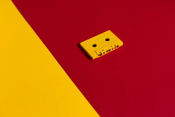 Жовтий аудіозапис на червоний поверхні, Top погляд. Творчі концепції ретро технології — стокове фото