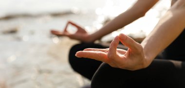 Nilüfer pozisyonunda yoga dersi veren tanınmayan bir kadın Ardha Padmasana egzersizi yapıyor. Vücudunun bir kısmını kapatıyor. Biyohack kavramı, meditasyon, nefes alma, akıl sağlığı. Metin alanı olan pankart