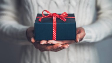 Kadın Elleri Kırmızı Fiyonklu Bir Hediye Tutuyor, Yakın plan. Noel Yeni Yıl Tatili konsepti