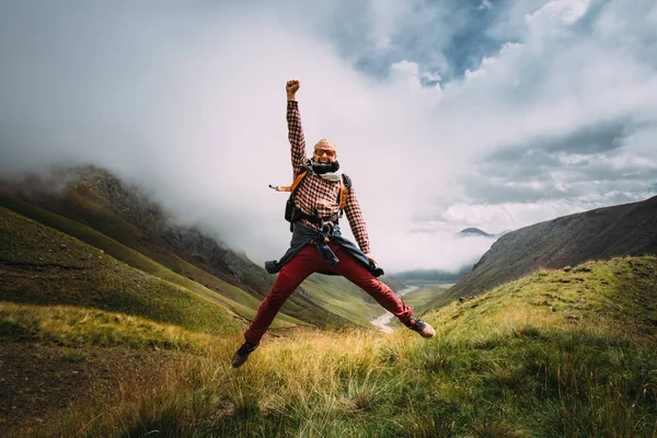 Jovem Viajante saltando com a mão para cima e sorrindo para alcançar o objetivo. Motivação, Viajar, Aventura, Conceito de Realização — Fotografia de Stock