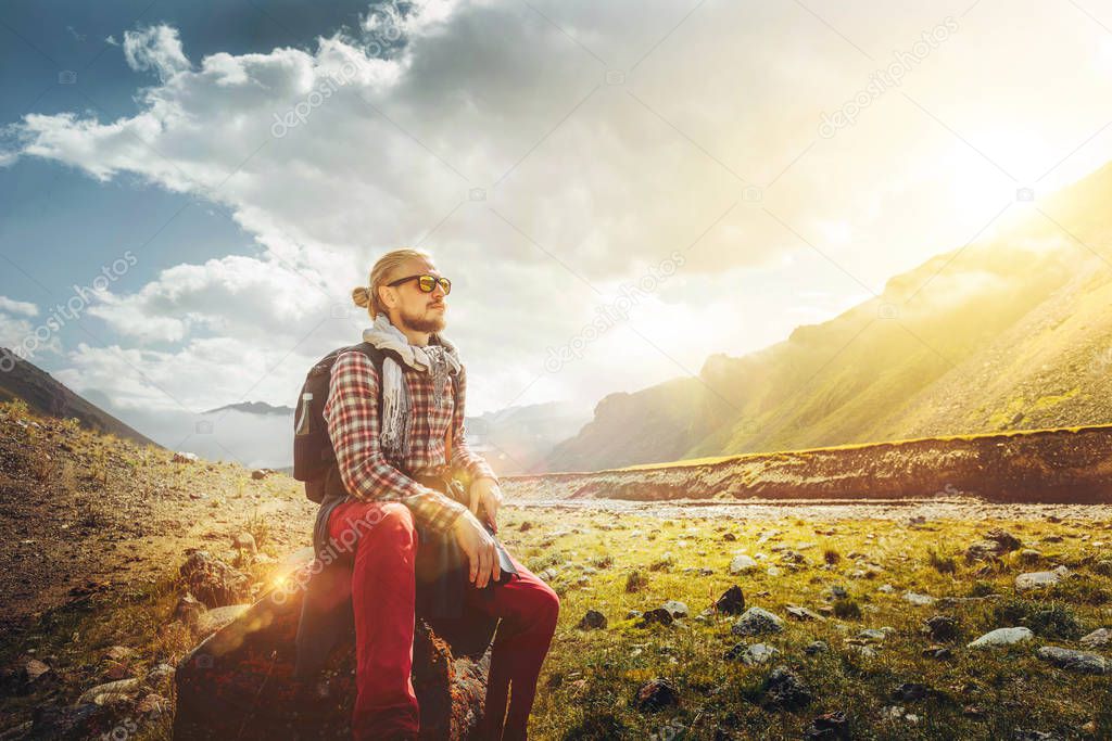 Traveler Man Sitting On A Background Of A Picturesque Mountain Landscape. Motivation, Travel, Adventure, Achievement Concept