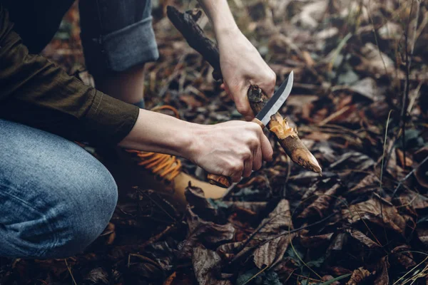 Mujer viajero avión cuchillo con palo de madera, Manos de cerca. Concepto de supervivencia y exploración de bosquejos —  Fotos de Stock