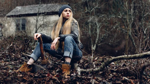 Ormanda dinlenen çekici kız elinde bir balta tutuyor. Bushcraft Hayatta Kalma Konsepti