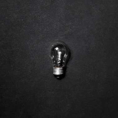 Ampul gri arkaplanda izole edildi, üst görünümde. Yaratıcı Fikir Kavramı