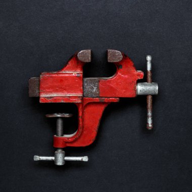 Metal çalışma aracı - kırmızı vintage mekanik el mengene Gri arkaplan üzerinde kopyalama alanı ile kıskaç