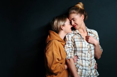 Genç eşcinsel çift portresi, siyah arka planda fotokopi çekilen lezbiyen kadınlar. Aşk, aile, eşcinsel evlilik ve gurur kavramı