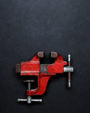 Metal işi aracı - kırmızı vintage mekanik el mengene mengene gri arkaplan üzerinde fotokopi alanı, üst görünüm. Yaratıcı tasarım fikri