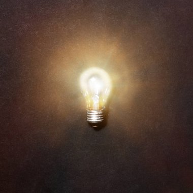  Parlayan ampul. Gri arkaplandaki tungsten ampulünün gerçekçi görüntüsü, üst görünüm. Yaratıcı fikir kavramı