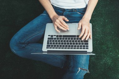 Karantina karantinası sırasında yeni haberler alıyoruz. Görsel dijital detoks. Dizüstü bilgisayarla yerde oturan sıradan elbiseli tanınmayan bir kız..