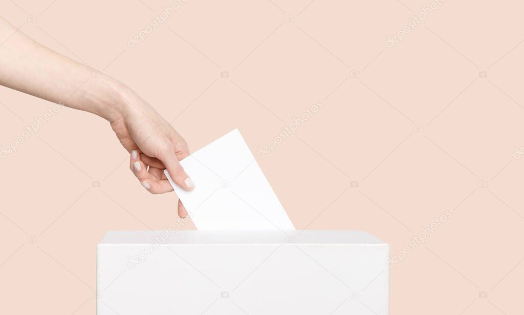 Civilized Equal Rights Concept. Female Hand Lowers Ballot In Ballot Box On Light Suntan Peach Background