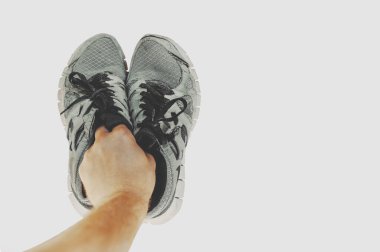 Eldeki eski spor ayakkabıları kopyalama alanı olan beyaz arkaplanda izole edilmiş