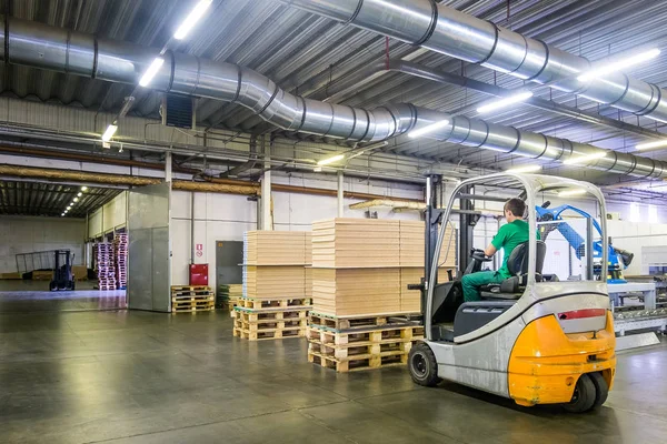 Car loader in the workshop of the furniture factory