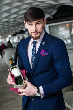 Genç şarap garsonu kırmızı şarap ikram ediyor.