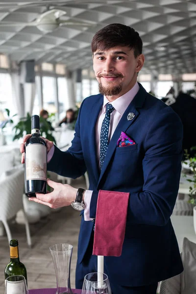 El joven sommelier ofrece vino tinto —  Fotos de Stock