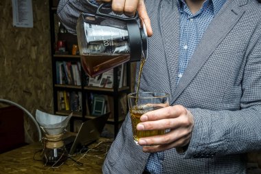 Barista bardağa kahve doldurur.