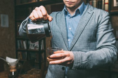 Barista bardağa kahve doldurur.