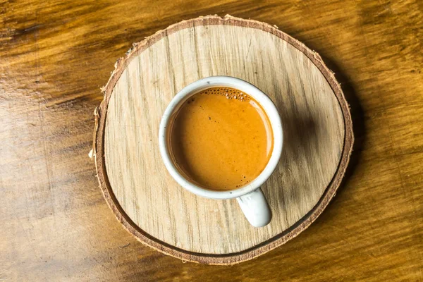 Белая чашка кофе на деревянном подставке — стоковое фото