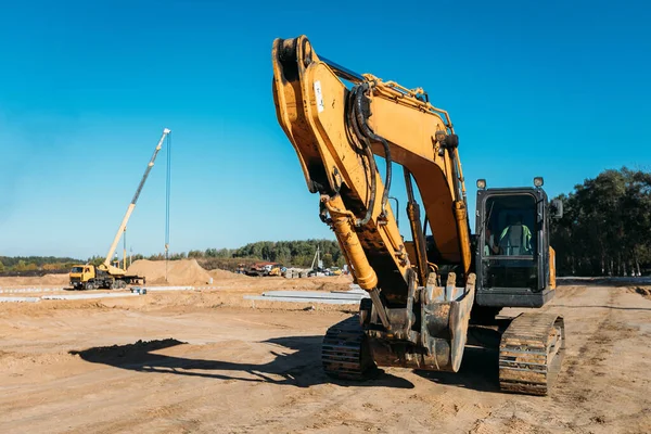 晴れた日に建設現場で大きな黄色の掘削機の正面図 — ストック写真