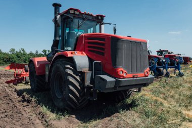 Rusya 'daki sergi sırasında yapılan testler sırasında büyük tekerlekleri olan kırmızı traktör.