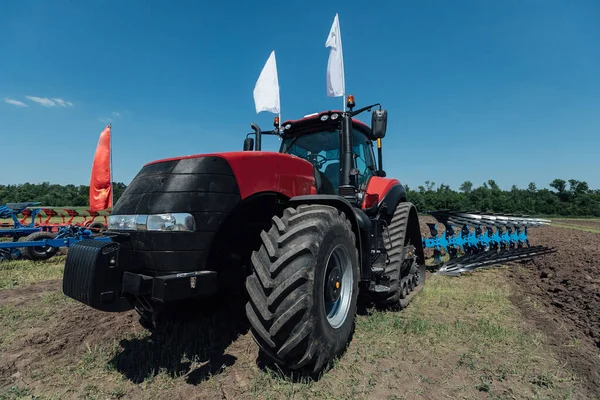 在俄罗斯展览期间的测试中 红色拖拉机 在田里有大轮子 — 图库照片