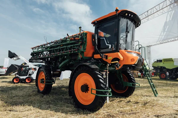 农业贸易展览会田里的橙色拖拉机喷雾器 — 图库照片