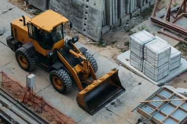 Sarı inşaat buldozerleri inşaat sahasında iş sırasında bir İHA tarafından yüksek bir yerden çekiliyor.