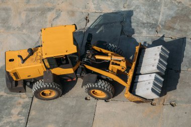 Sarı inşaat buldozerleri inşaat sahasında iş sırasında bir İHA tarafından yüksek bir yerden çekiliyor.