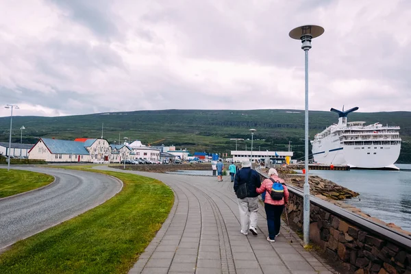 観光客の高齢者のカップルがアイスランドの北のAkureyriの桟橋に行く大きな白いクルーズ船の夏がある — ストック写真