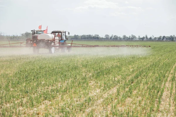 chemical treatment of plants to protect against pests using a tractor in the field