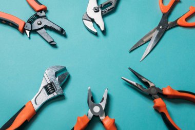 Mavi arka planda turuncu saplı bir grup araç düzgünce yerleştirildi