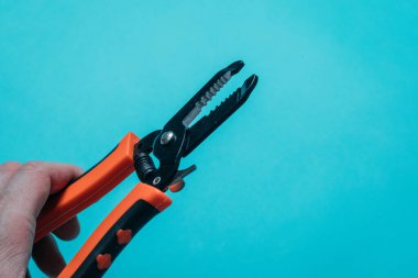 Mavi arka planda turuncu saplı siyah kesiciler düzgünce serilmiş.