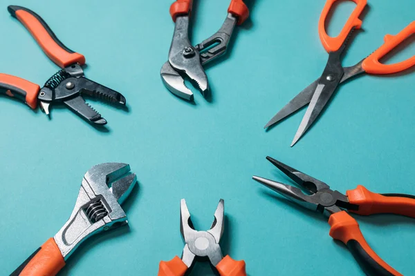 group a bunch of tools with orange handles on a blue background laid out neatly