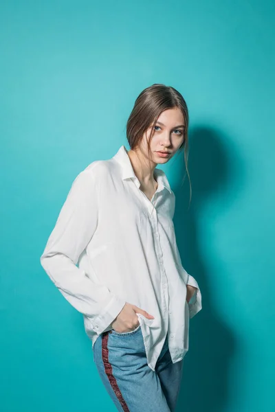 Młoda Dziewczyna Białej Koszuli Dżinsach Laptopem Niebieskim Tle Studio — Zdjęcie stockowe