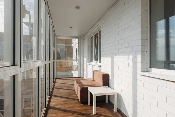 Güneşli bir sabahta, en üst kattaki bir apartmanın modern beyaz loggia balkonunda.