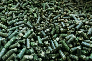 Bir depoda çok sayıda yonca yeşil granülü tarımsal yem ambalajı için hazırdır.