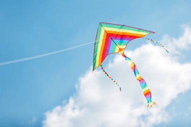 Öğleden sonra mavi gökyüzüne karşı ipte çok renkli bir uçurtma.