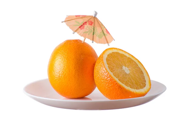 Naranjas con paraguas en plato blanco — Foto de Stock