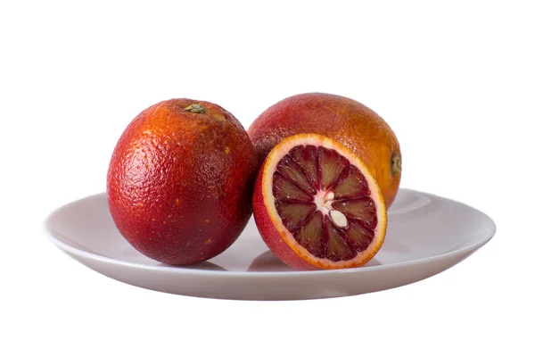 Красные апельсины на белой тарелке — стоковое фото
