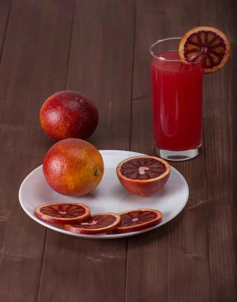 Свіжий червоний апельсиновий сік з нарізаним апельсином на столі — стокове фото