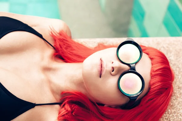 Κορίτσι με τα κόκκινα μαλλιά περούκα σε μαύρο μπικίνι και γυαλιά ηλίου — Φωτογραφία Αρχείου