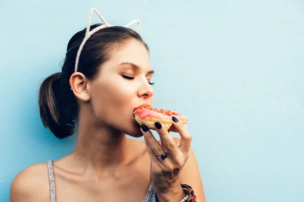 Attrayant brunette sexy femme manger savoureux beignet — Photo