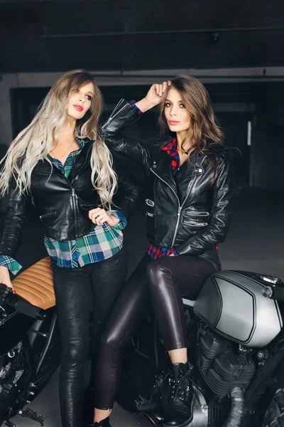 Mulheres motoqueiros em jaquetas de couro com motocicletas — Fotografia de Stock