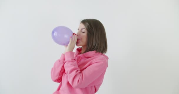 Νεαρή γυναίκα φυσάει μπαλόνι — Αρχείο Βίντεο