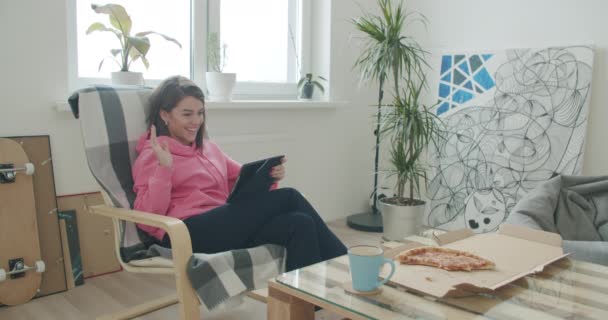 Женщина отдыхает дома, держа цифровой планшет — стоковое видео