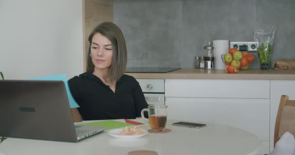 Woman working with papers sitting in kitchen at home. — Stock Video